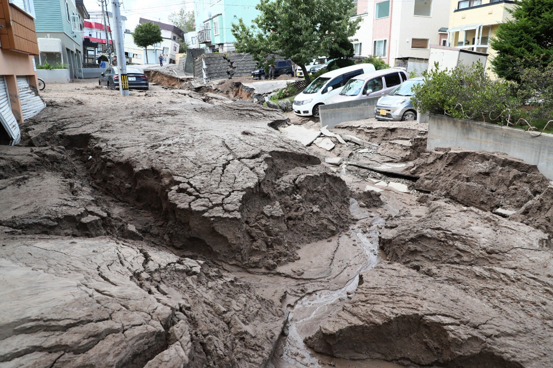 Carros estacionados ao longo de uma estrada danificada pelo terremoto (Foto: AFP PHOTO / JIJI PRESS / JIJI PRESS / Japan OUT)