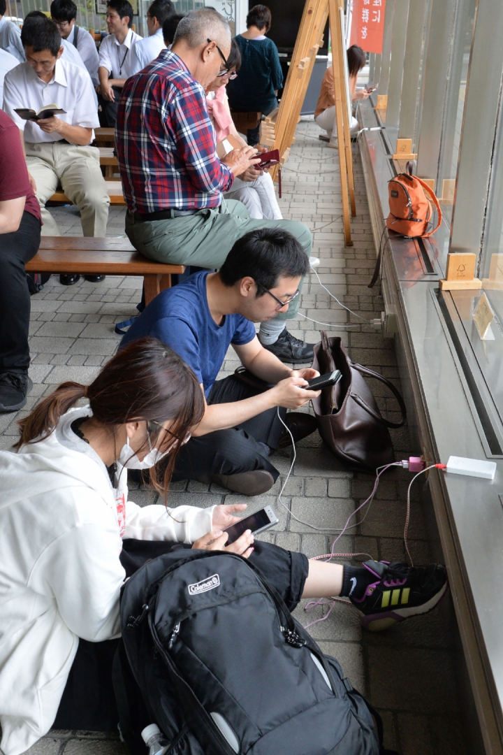 Moradores carregam seus celulares em Sapporo (Foto: AFP PHOTO / JIJI PRESS / JIJI PRESS / Japan OUT)