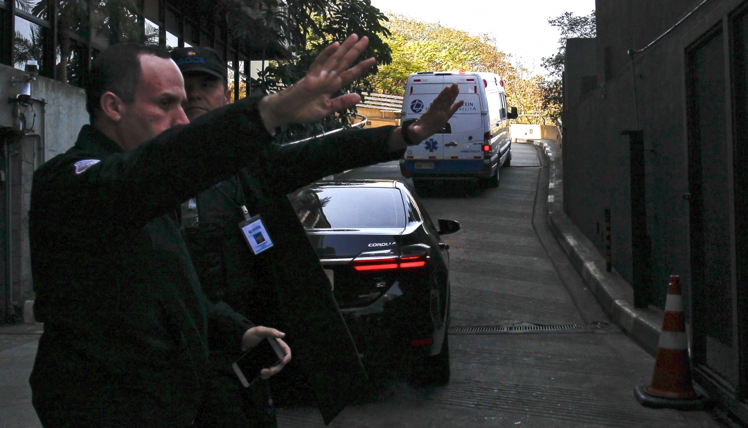 Guardas dão a direção para a ambulância que transportou Bolsonaro para o Albert Einstein (Foto: AFP PHOTO /RAYSA LEITE; MIGUEL SCHINCARIOL)