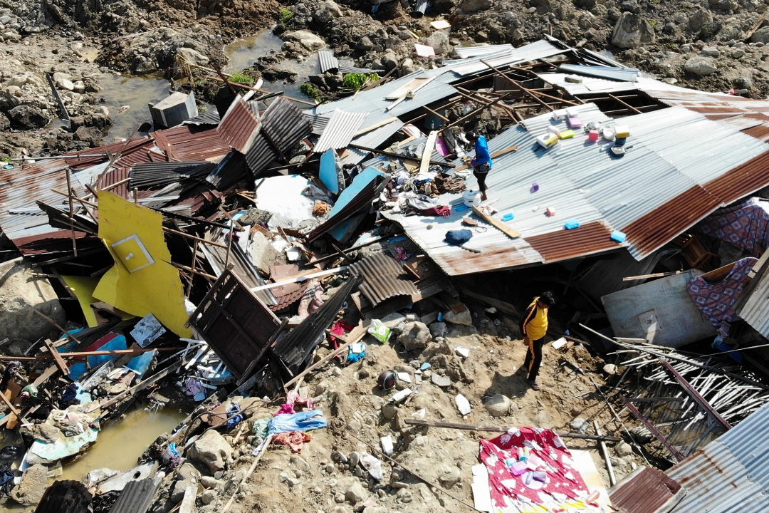 Sobreviventes salvam itens dos destroços de uma casa destruída em Palu (Foto: AFP PHOTO / Jewel SAMAD; Ola Gondronk; Adek BERRY; Mohd RASFAN)