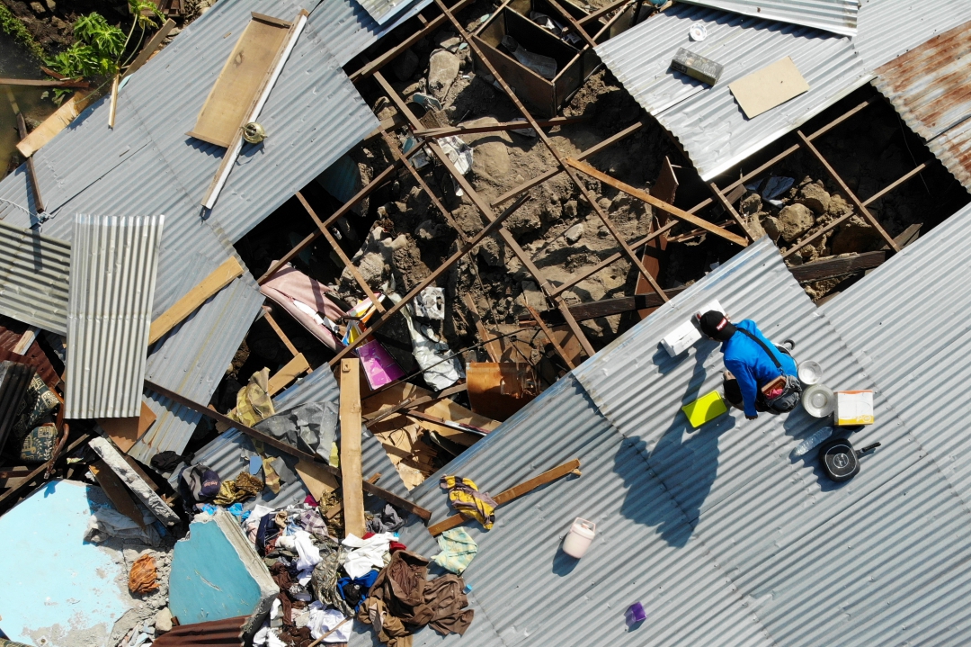 Sobreviventes salvam itens dos destroços de uma casa destruída em Palu (Foto: AFP PHOTO / Jewel SAMAD; Ola Gondronk; Adek BERRY; Mohd RASFAN)