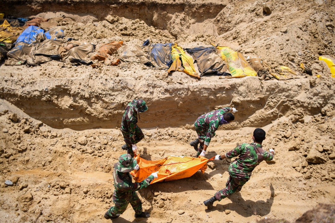 Indonésios enterram vítimas do terremoto em uma vala comum em Poboya
(Foto: AFP PHOTO / Jewel SAMAD; Ola Gondronk; Adek BERRY; Mohd RASFAN)
