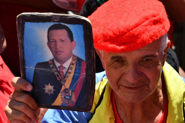 Senhora venezuelana segura foto de Hugo Chávez em ato Hands Off Venezuela, contra intervenção militar no país (Photo by Yuri CORTEZ / AFP) (Foto: Yuri Cortez/AFP)