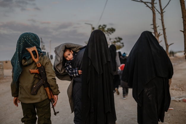 Ao lado, muçulmanas
que fugiram do último redito jihadista na Síria caminham ao lado de combatente das Forças Democráticas da Síria. Abaixo, mulheres que deixaram Baghuz
aguardam para ser revistadas. Cerca de 50 mil pessoas, a maioria mulheres e crianças, saíram da região e foram levadas para acampamentos
(Foto: Fotos de Bulent Kilic/AFP)