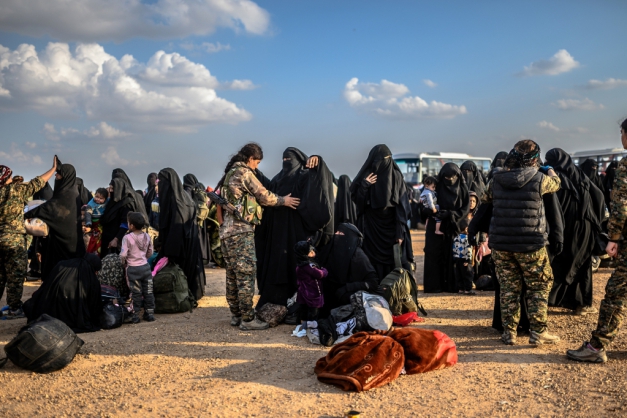 Mulheres que deixaram Baghuz, último reduto jihadista na Síria, são revistadas pelas Forças Democráticas da Síria, em posto de controle de acampamento para deslocados (Foto: Bulent Kilic/AFP)