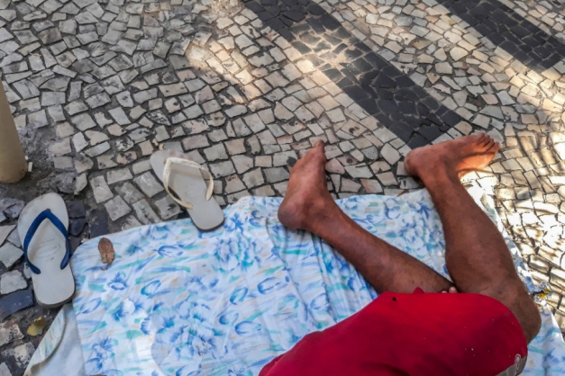 Acima, as pernas e pés sujos do morador sobre pedras portuguesas; à dir., a elegância do homem na Rua Sete de Setembro, com óculos vermelhos que combinam com a pequena sereia; abaixo, aquele que escolheu as areias da praia para dormir (Foto: Américo Vermelho)