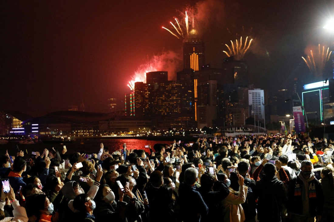 Fogos de artifício explodem sobre a construção do horizonte para celebrar o Ano Novo em Hong Kong, China Macaque in the trees