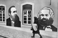 Senhora passa em frente a 'retratos' de Friedrich Engels e Karl Marx