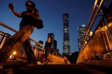 Pedestres caminham em um viaduto perto de arranha-céus no Central Business District, em Pequim