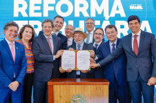 O presidente exibe a lei recém-sancionada ao lado de ministros, deputados e senadores, no Palácio do Planalto