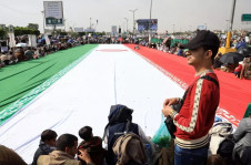 Manifestantes em torno da bandeira do Ir&atilde;