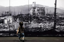 Menino olha imagem de destruição a bomba em Hiroshima em museu na cidade