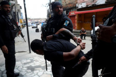 Um homem é detido por policiais durante a operação policial contra o tráfico de drogas na favela da Penha, no Rio de Janeiro