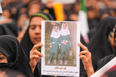 M&atilde;e luto exibe fotos de suas filhas que foram mortas, durante o funeral das crian&ccedil;as que perderam a vida ap&oacute;s um ataque a uma escola prim&aacute;ria na prov&iacute;ncia de Hormozgan, no Ir&atilde;, em 3 de mar&ccedil;o de 2026, em Minab, Ir&atilde;. Milhares de pessoas, incluindo familiares e autoridades, compareceram &agrave; cerim&ocirc;nia