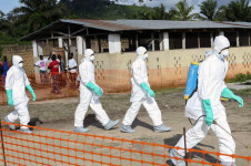 Profissionais de sa&uacute;de liberianos com equipamentos de prote&ccedil;&atilde;o individual a caminho do enterro de uma mulher que morreu de Ebola na unidade de isolamento em Foya, Condado de Lofa, Lib&eacute;ria (arquivo)