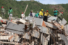 Pessoas buscam por v&iacute;timas entre os escombros de um pr&eacute;dio que desabou ap&oacute;s terremotos em Caracas