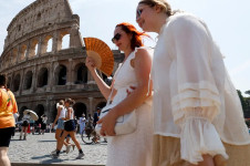 Mulher se refresca com um leque perto do Coliseu durante uma onda de calor em Roma
